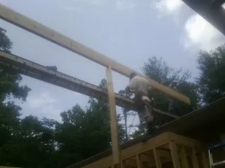 Carpenter setting a ridge beam over a new addition frame — Ice Dam Removal by Roofing Brothers in Cherryville