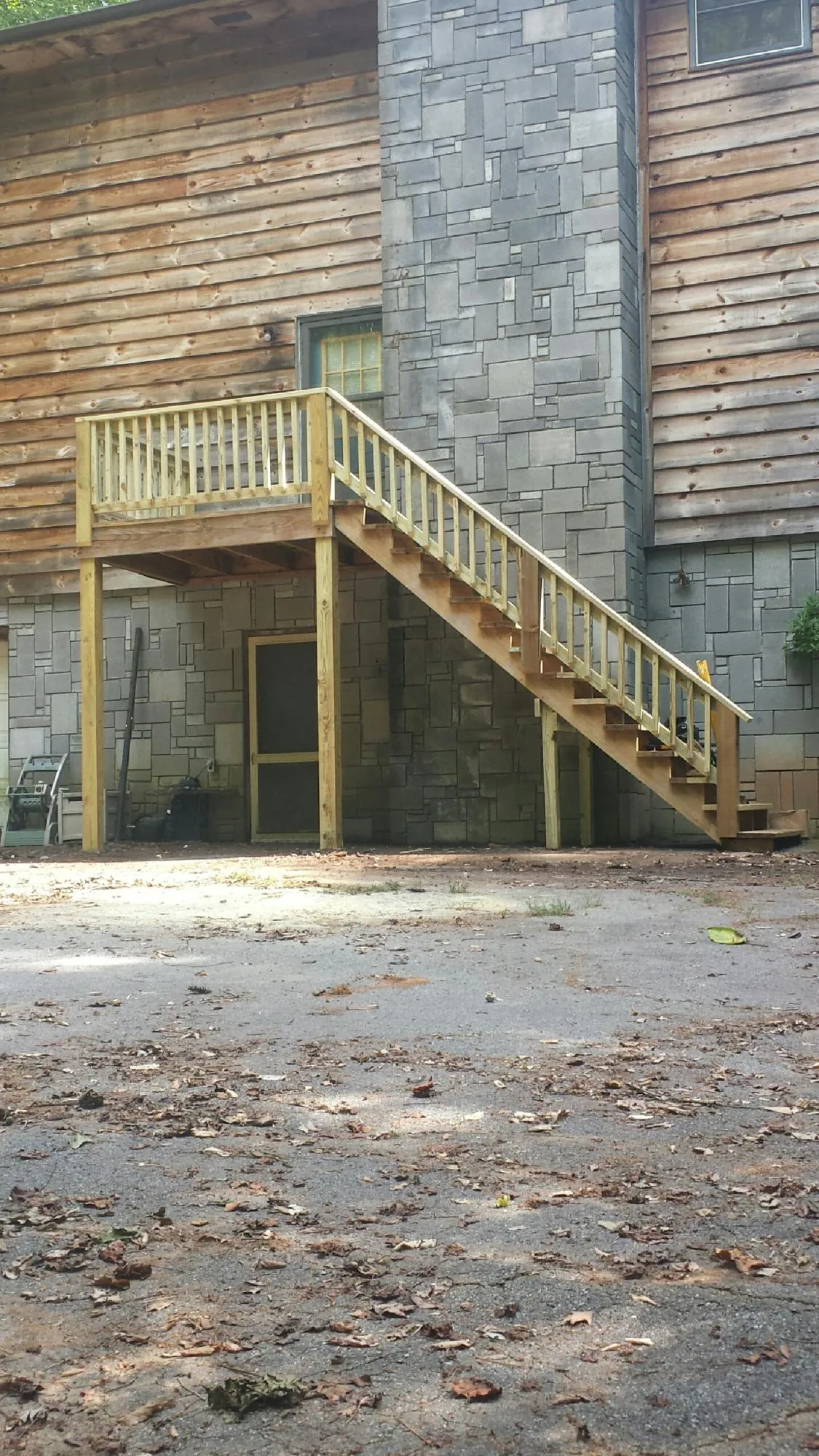 New pressure treated deck and stair landing on a log home in Cherryville
